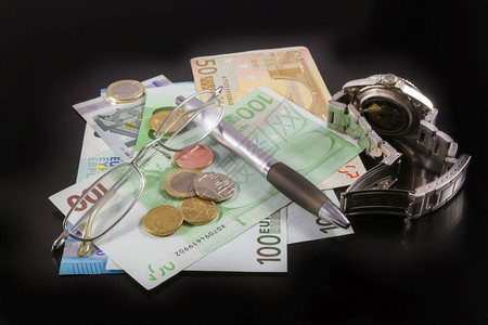 百欧元钞票硬币笔眼镜和黑人背景观察商业和办公室概念股票工作图片