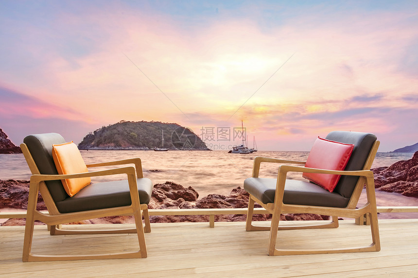 户外日落海观露天平台上的木椅子制图片