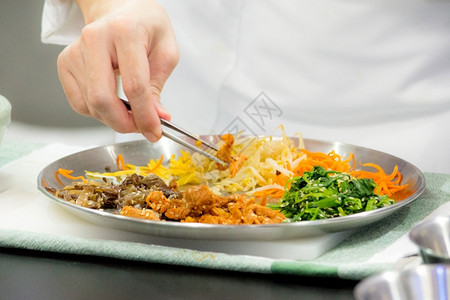 碗Bibimbip朝鲜食品厨师准备物膳厨房烹饪传统的手图片