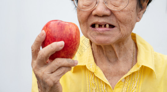 吃红苹果的老年妇女图片