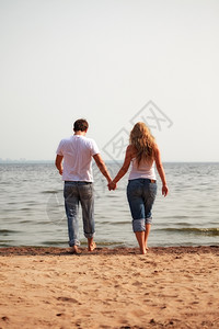 年轻夫妇在海滩上行走图片
