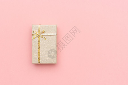 粉红色礼品盒惊喜天纸Beige礼品盒在粉色糊面背景上用箭头在粉红色画面背景上鞠躬以最小的风格展示TopView复制空间模拟设计图片