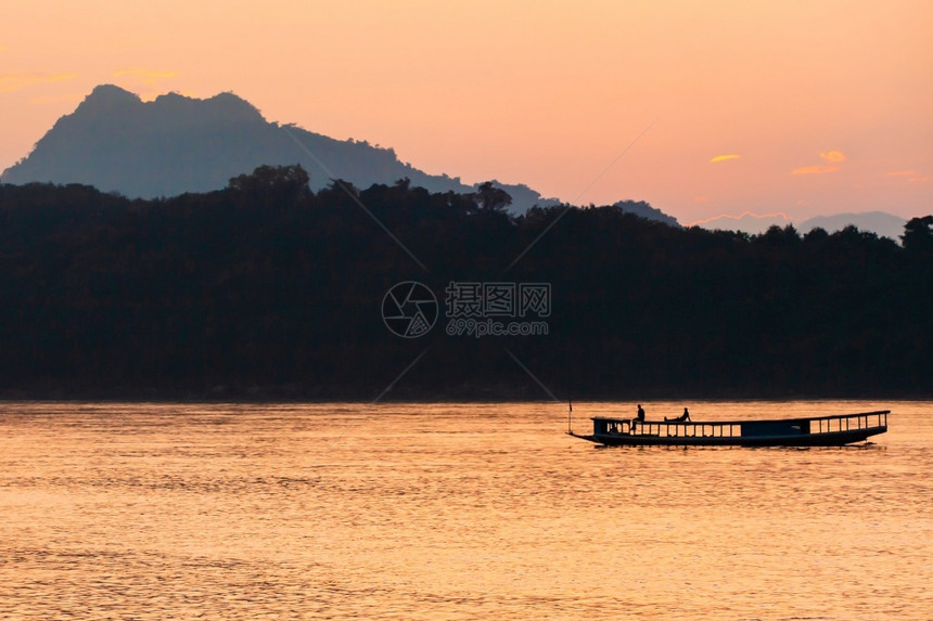 运输在老挝LuangPrabang黄昏的湄公河上一艘当地渡船屋顶上放松旅游者一种当地的图片