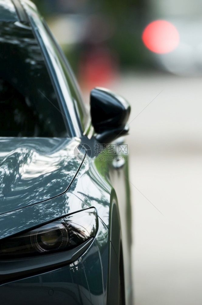 外观玻璃对停在街上汽车刹灯和停在背景模糊的车上现代清洁明亮橄榄绿色汽车的前对面视线关注侧镜子图片