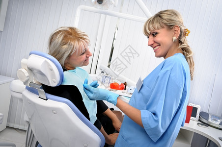 白种人满意积极的与病人一起工作的牙医检查清洁治疗使用牙科水喷气机图片