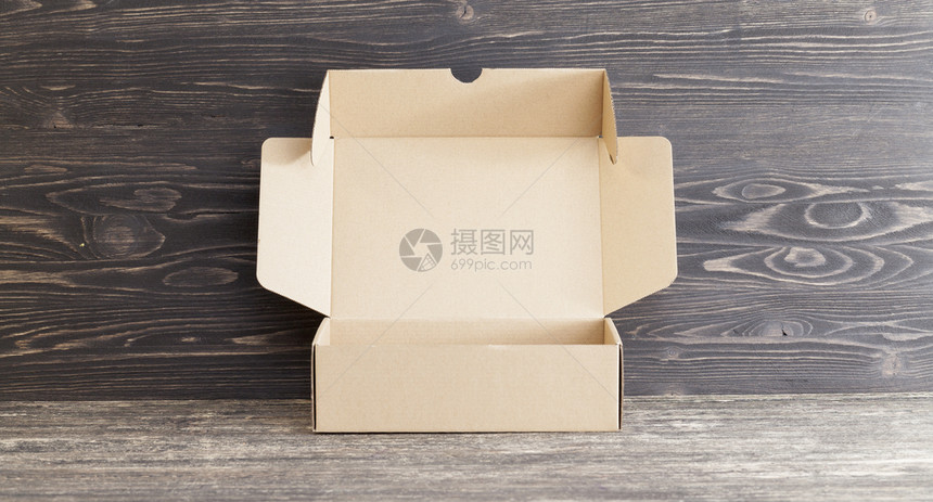 最佳平坦的装在黑色木制表面的纸板箱用于包装发运货物和其他的纸板盒邮政图片