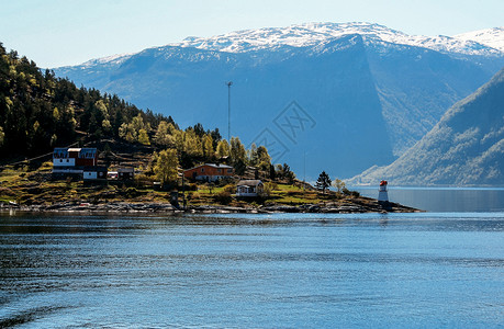 沿海岩石信标白色灯塔在挪威码头海岸上红色高的白灯塔图片
