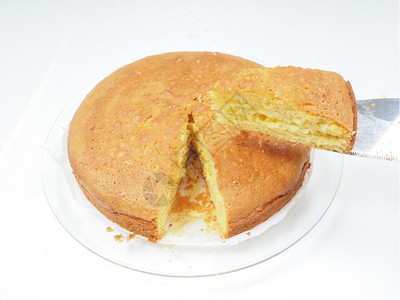 一个人拿着块新鲜烤蛋糕在上向白的煎饼堆贝图姆圆圈糕点图片