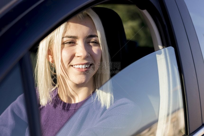 女士快乐的日落时年轻微笑的女青年驾驶车保险图片