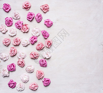 花的回收包裹白木背景上堆叠着不同颜色的纸玫瑰情人节日图片