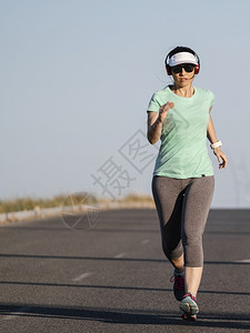 草妇女沿路奔走听音乐跑步动机图片