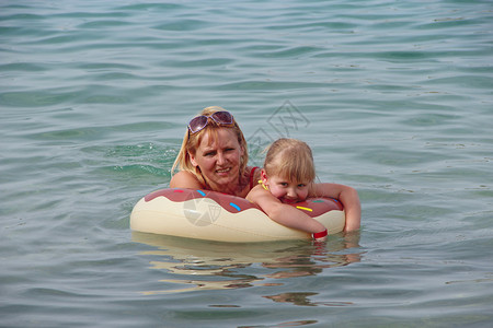 游泳圈游泳的母女图片