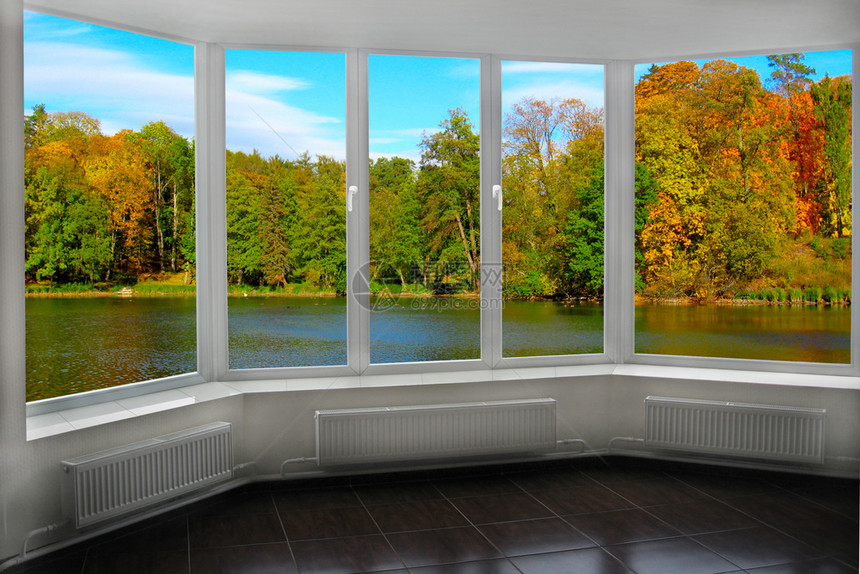 带窗户的房间可以看到秋天的森林和湖泊秋天的风景和森林中湖泊从房间窗户可以看到大自然的全景从窗户可以看到彩色的秋天树木的风景内部户图片