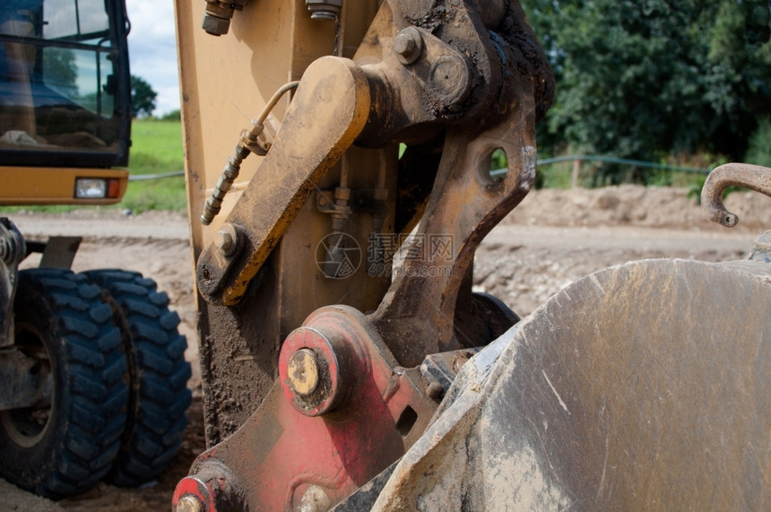 工具重的承包商在背景中用挖土机的铲子缝合图片