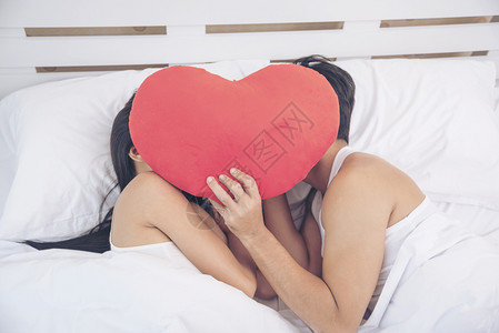 浪漫情侣人看其他关注焦点在床上的美人对男朋友爱概念微笑的床女人心士恋爱图片