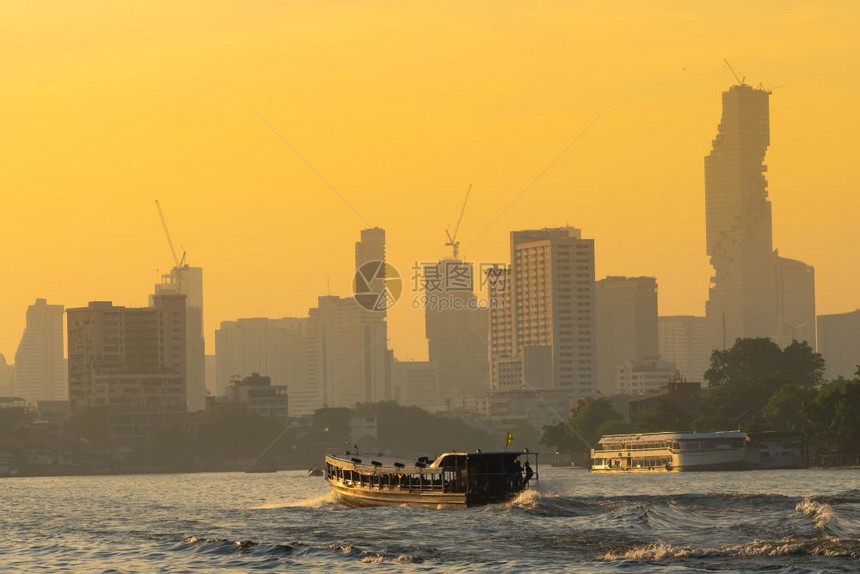 曼谷市晚夜的船河交通日落时建造摩天大楼背景塔建筑学人们图片