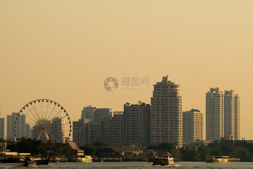 曼谷市晚夜的船河交通日落时建造摩天大楼背景旅游城市图片