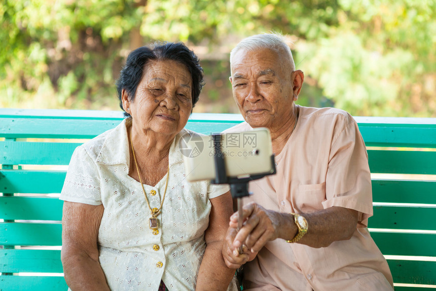 成熟旅行电话快乐的老夫妇在家里装自拍图片