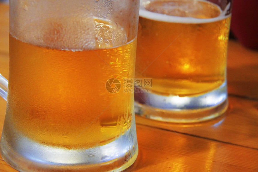 液体可口在咖啡厅的木制桌上两杯透明的子啤酒吧图片