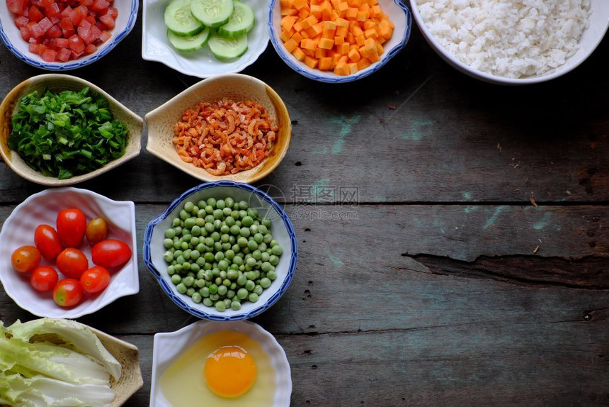 亚洲人越南食物炒饭大米鸡蛋香肠干虾豆黄瓜番茄胡萝卜和扇菜用木制的多彩食品加工越南的白饭图片