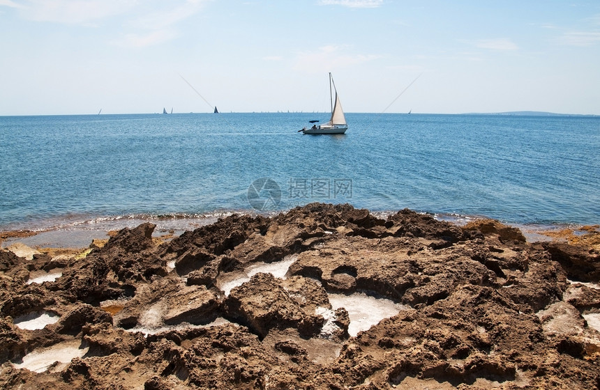 沉淀美丽的自然海岸景观在马洛卡西班牙海岸盐洞和水的松绿蓝中岩石和帆船含盐孔户外晴天图片