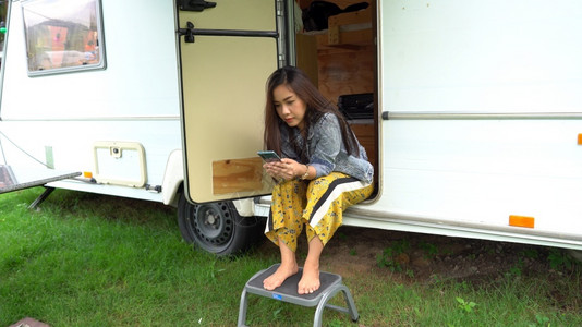 夏日坐在野营车里的美丽年轻女士家庭的闲暇图片