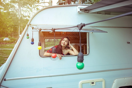 夏日坐在野营车里的美丽年轻女士自然房车航程图片