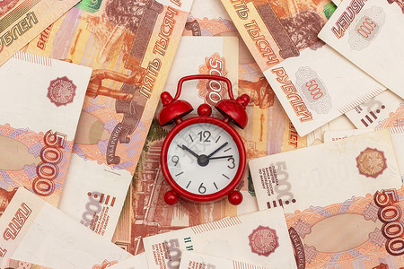 五镑钞票现金俄罗斯千分之五钞票背景上的红色闹钟概念时间就是金钱俄罗斯千分之五钞票背景上的红色闹钟概念时间就是金钱经济的成功背景