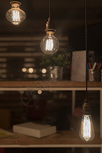 挂在电线上的低瓦特钨丝灯泡照亮低的灵感图片