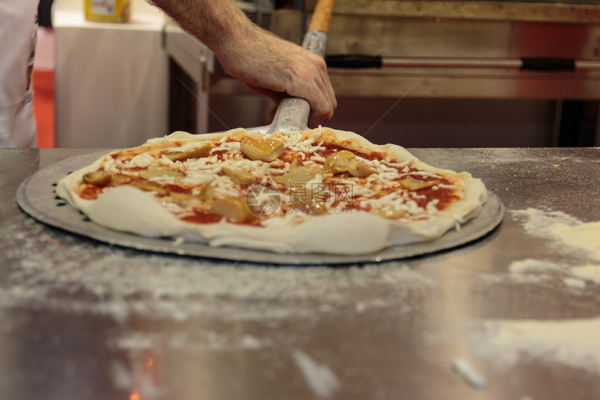 番茄面包餐厅将Raw披萨放入Oven和Spatula意大利蘑菇图片
