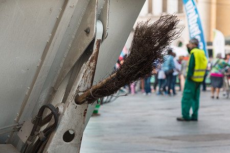 卡车污染在公共街道使用清洁工具进行扫的市政尘土工人城的图片