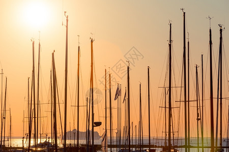 奢华桅杆夏天晚上码头的渔船排行数与日落和黄昏照明图片