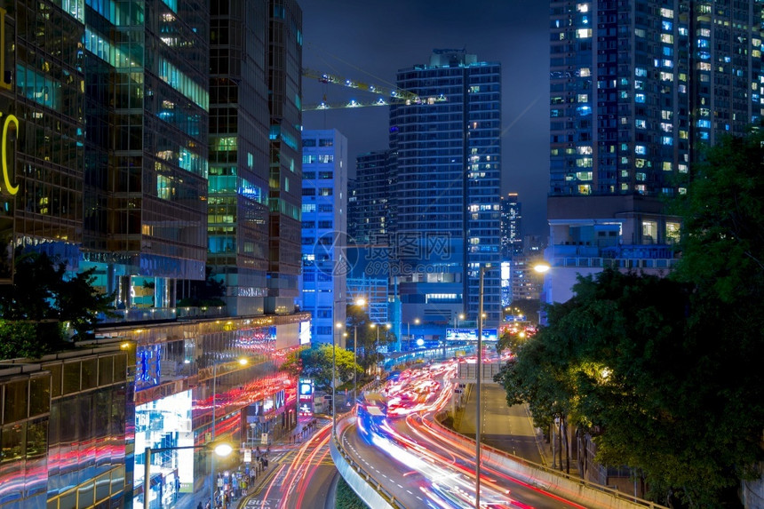 现代的曼哈顿香港市夜间街道香港前和后灯的大批车行道夜交通香港街上有很多车轨路图片