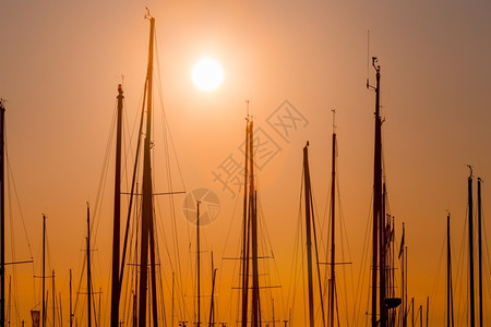 晚上码头的渔船排行数与日落和黄昏照明游艇漂浮的夏天图片