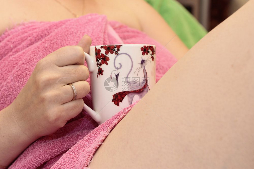 茶白色的女人在洗浴后用粉色毛巾喝白红杯咖啡室内的图片