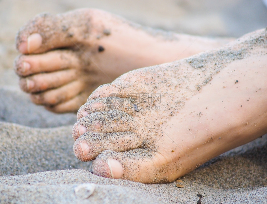 沙玉米水平的说谎一个无法辨认的天主教徒脚躺在沙土中脚下有湿沙图片