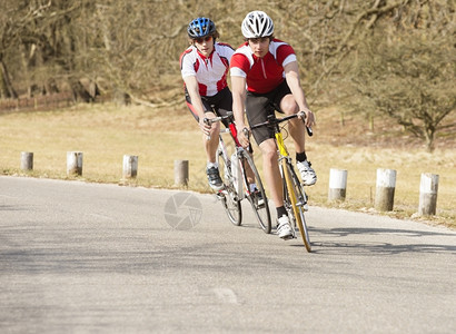 头盔循环夏天活跃的男骑自行车手在乡村公路上骑自行车图片