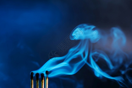 目的水平火柴刚在神秘的黑暗蓝光中熄灭在暗底背景下奇观的烟雾最小化文字的位置温暖背景图片