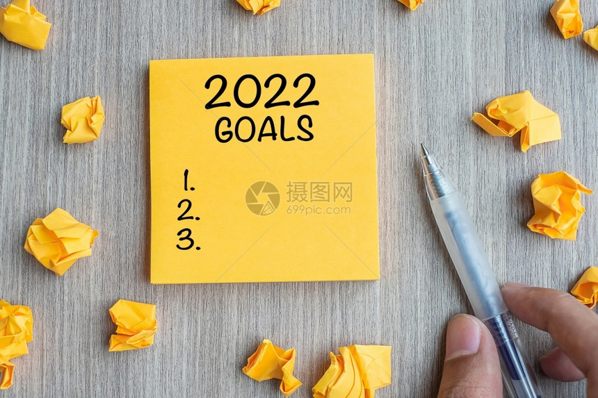 假期信息成功20年黄字目标由商人拿笔和纸碎写在木桌背景纸上的新开端决议战略任务概念图片