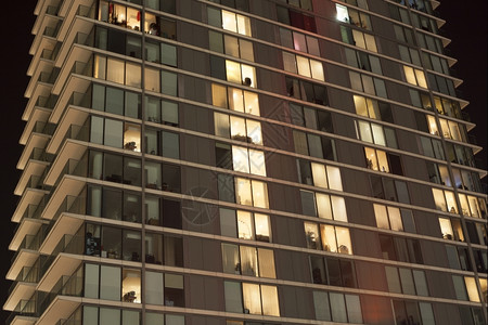 夜里现代公寓楼宽的灯光正面图片
