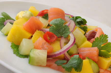 烹饪鲑鱼和椰菜芒果黄瓜红辣椒色的开胃菜图片
