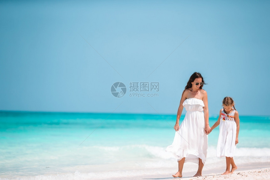 年轻美丽的母亲和她小女儿在海滩上美丽的母亲和女儿在海滩上享受暑假白种人为父母女图片