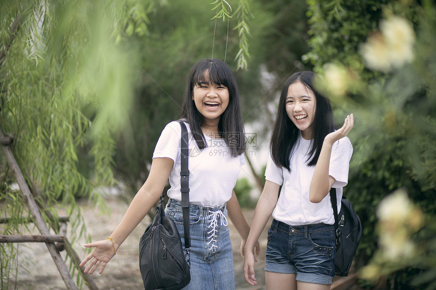 在绿色公园中欢笑的亚裔青少年快乐请享用女孩图片