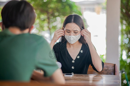 亚裔女使用面罩坐在餐厅软焦点新正常概念的餐饮中卫生保健男亚洲人图片