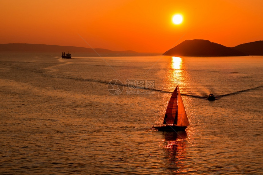 克罗地亚人得里海的日落及其在克罗地亚斯普利特港入口处的倒影中玩耍船只亚得里海的日落及其在克罗地亚斯普利特港入口处的倒影中玩耍船只图片