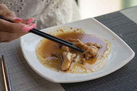 人女在餐厅吃亚洲菜鸡肉加和铁木酱还有筷子角度家禽图片
