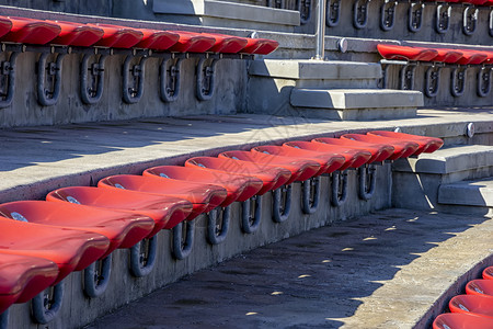 团体育场或两脚剧院台的空红色塑料椅子供观众用许多空座位在席上为观众使用许多空座位在近距离大厅为了背景图片