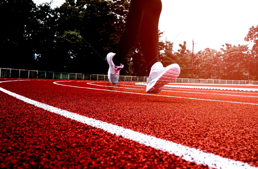 在体育赛场道上运动服装中的妇女跑步锻练的女者健康生活方式概念身体短跑运动员鞋图片