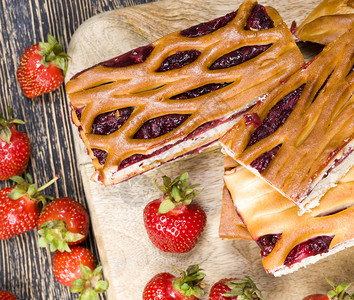 多汁的新鲜甜自制蛋糕加草莓和红美味果酱切成碎块用面粉烤的食物图片
