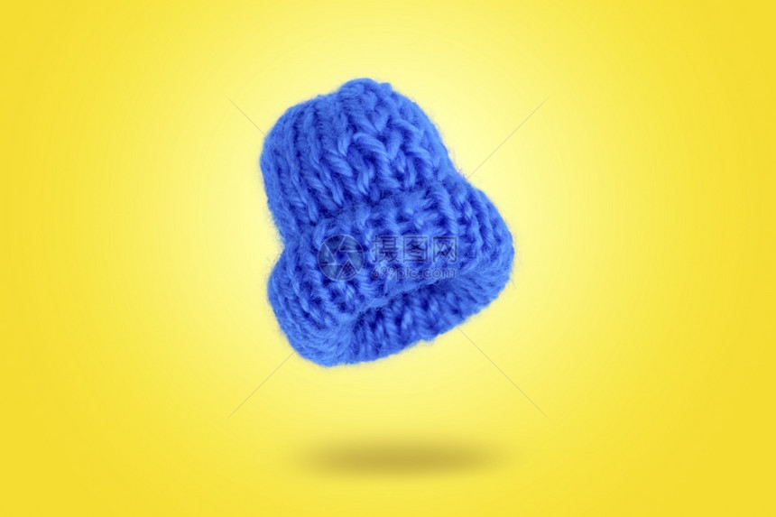 漂浮在黄色背景上的蓝编织帽子图像个人的蓝色服饰图片